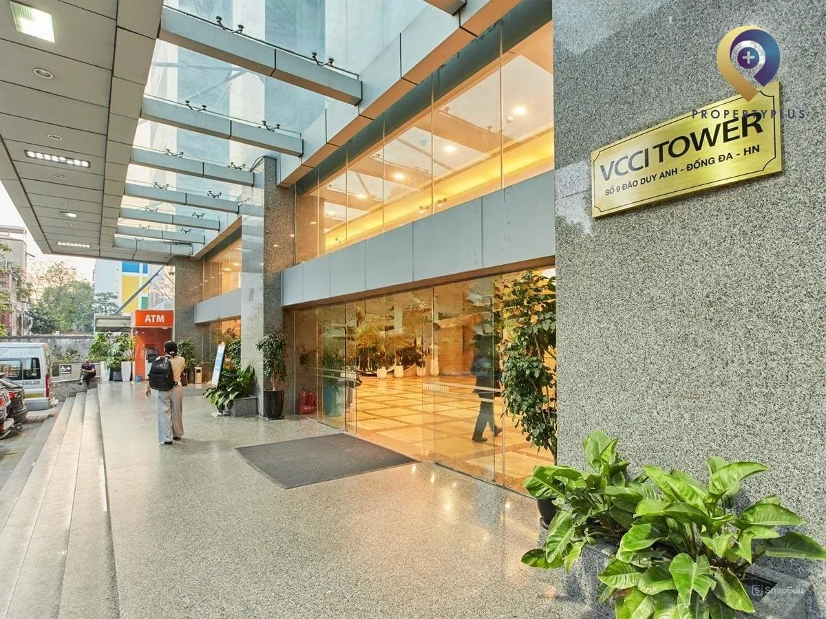 Lối vào chính tòa nhà VCCI Tower với mái che kính hiện đại, bảng tên tòa nhà và không gian phía trước.